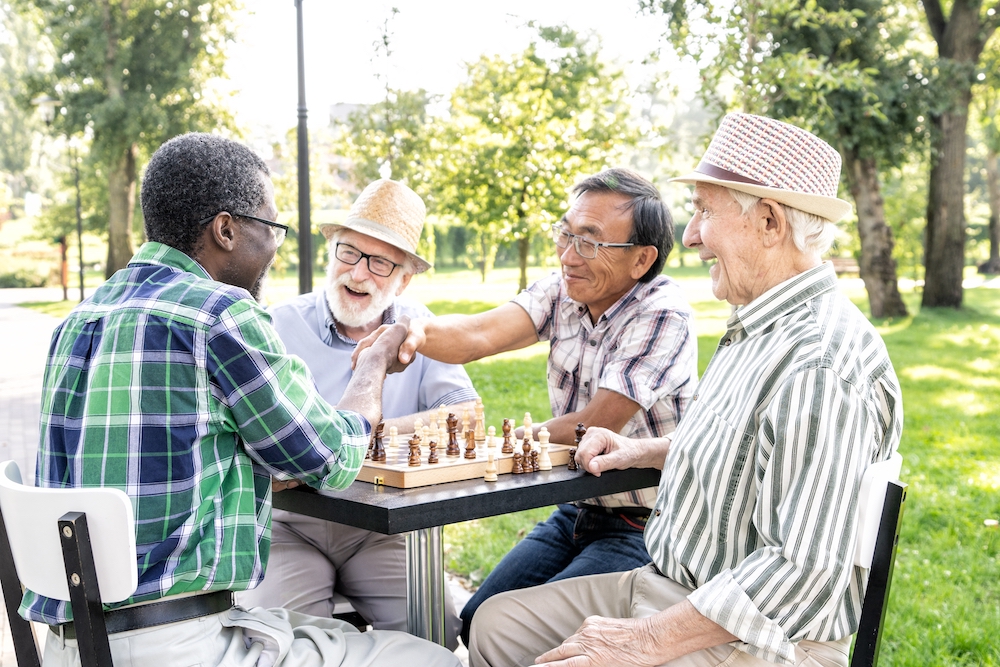 A group of senior men play chess and socialize at the Alzheimer care facilities in Vista
